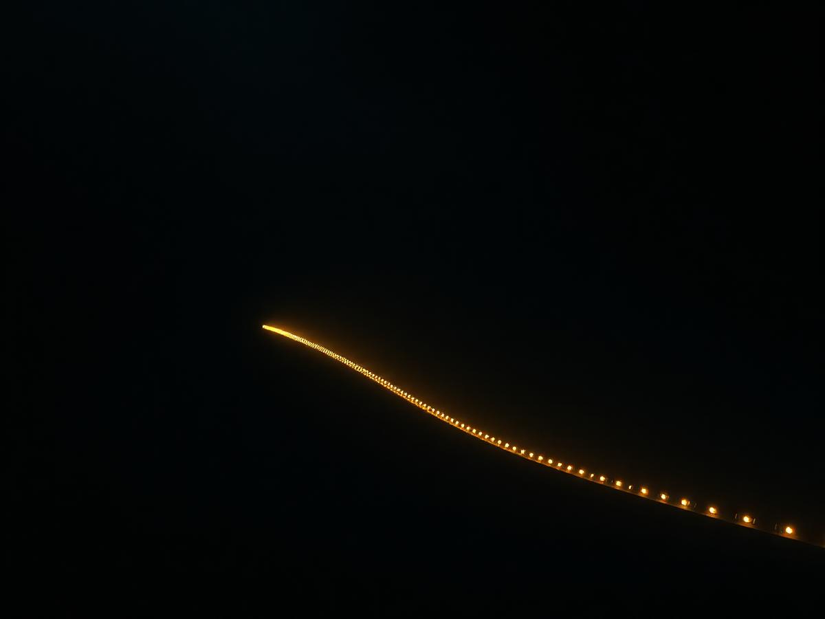 A single continuous line of gold light curving through darkness